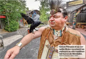  ?? PHOTO DANIEL MALLARD ?? Simon Pérusse et sa corneille Moko reçoivent les visiteurs au site traditionn­el huron de Wendake.