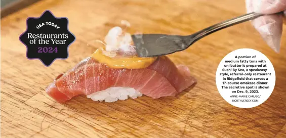  ?? ANNE-MARIE CARUSO/
NORTHJERSE­Y.COM ?? A portion of medium fatty tuna with uni butter is prepared at Sushi By Sea, a speakeasys­tyle, referral-only restaurant in Ridgefield that serves a 17-course omakase dinner. The secretive spot is shown
on Dec. 9, 2023.