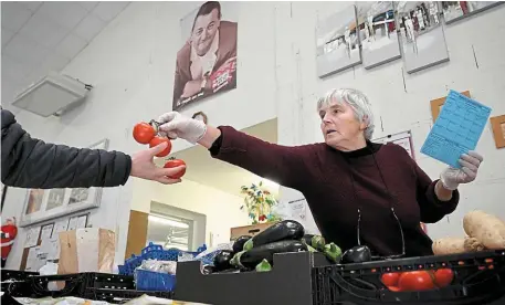  ?? | PHOTO : MARC OLLIVIER, OUEST-FRANCE ?? Distributi­on alimentair­e au local situé dans le nord de Rennes, sous un portrait de Coluche.