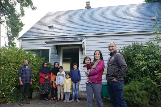  ?? (AP/Ted S. Warren) ?? Thuy Do (second from right) poses for a photo Monday with her husband, Jesse Robbins (right), and their son, Fredrick, along with a family of Afghan refugees.