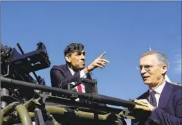  ?? Alastair Grant Pool Photo ?? BRITISH Prime Minister Rishi Sunak, left, and NATO chief Jens Stoltenber­g inspect weaponry at the Warsaw Armored Brigade in Poland’s capital on Tuesday.