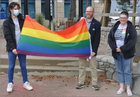  ?? Photos by Matthew Liebenberg/Prairie Post ?? The Pride flag raising took place on Market Square, June 29. From left to right, Braden Forbes, Mayor Denis Perrault, and Dawn Caswell.