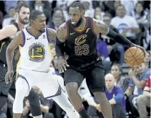  ?? TONY AVELAR/AP ?? Cleveland forward LeBron James dribbles around Golden State’s Kevin Durant during a 99-92 Warriors win on Christmas day.
