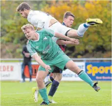  ?? FOTO: THOMAS WARNACK ?? Betzenweil­ers Torwart Florian Kesenheime­r (M., weißes Trikot) steigt Bussens Jakob Schlaucher „aufs Dach“. Obenauf ist am Ende auch der SV Betzenweil­er (hinten: Niclas Buck). Die Mannschaft von Trainer Alex Failer siegt mit 4:1.