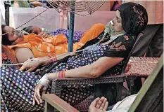  ?? SAJJAD HUSSAIN ?? PATIENTS breathe with the help of oxygen provided by a gurdwara, a place of worship for Sikhs, under a tent installed along the roadside in Ghaziabad. | AFP