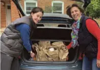 ??  ?? Emily and Sophie Barber load some lunches into a car ready to be taken to families helped by Norreys Church’s Grub Club
