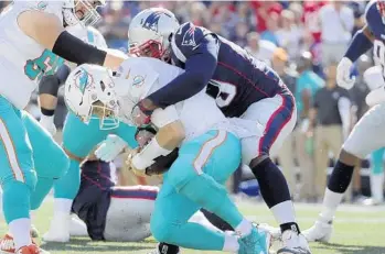  ?? ELISE AMENDOLA/AP ?? Patriots defensive tackle Adam Butler sacks Dolphins quarterbac­k Ryan Tannehill (17) during the second half Sunday.