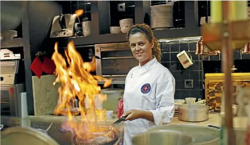  ?? HUGO CORREIA/REUTERS HUGO CORREIA/ REUTERS ?? Sardines and codfish are a common site on menus in the Portuguese capital. Chef Susana Felicidade cooks at Ribeira Market in Lisbon.