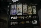  ?? ARIANA CUBILLOS — THE ASSOCIATED PRESS ?? A cash register drawer holds Bolivars and U.S. currencies at a shop in Caracas, Venezuela, on Friday.