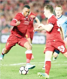  ?? - AFP photo ?? Liverpool’s Daniel Sturridge (L) scores a goal against Sydney FC during their end-of-season friendly football match at the Olympic Stadium in Sydney.