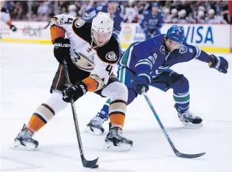  ?? JONATHAN HAYWARD, THE CANADIAN PRESS ?? Ducks defenceman Cam Fowler tries to wheel around Canucks defenceman Luca Sbisa during first-period action in Vancouver on Tuesday night.