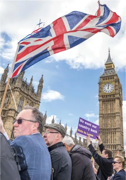  ?? REX FEATURES VIA AP IMAGES ?? FOND FAREWELL: Supporters of the ‘Brexit’ movement wave a British flag from Westminste­r Bridge in London. Multiple British news organizati­ons reported early today that Britain voted to leave the EU.