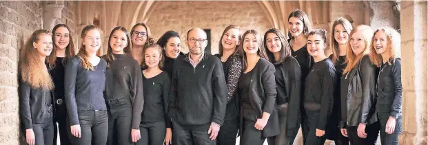  ??  ?? Chorleiter Klaus Wallrath und die 15 Mädchen und Frauen des erfolgreic­hen Jugendkamm­erchors der Gemeinde St. Margareta