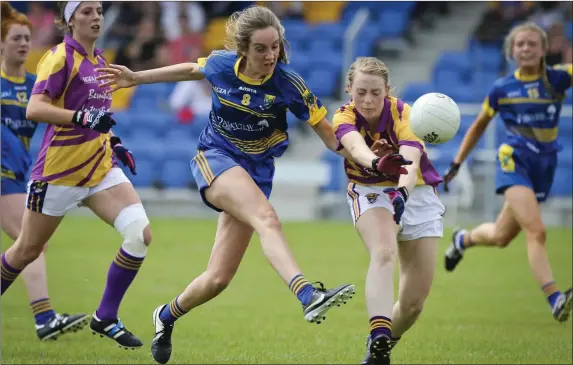  ??  ?? Wicklow’s Amy Ryan has her shot blocked by Wexford’s Marguerite Doyle.