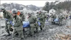  ?? PICTURE: REUTERS ?? AFTERMATH: Japanese military carry bodies of tsunami victims in March.