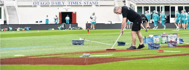  ?? PHOTO: PETER MCINTOSH ?? Sweep shot . . . Peter Ryder, of Williams Signs and Graphix, paints a logo on the ground surface in preparatio­n for today’s T20 between New Zealand and Australia at the University Oval.