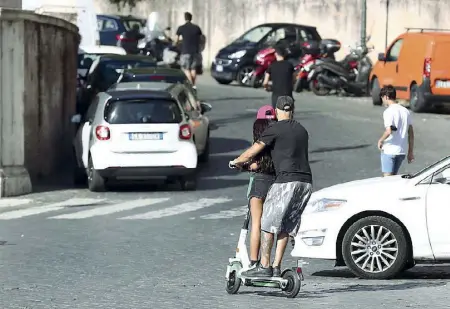  ??  ?? Piazza del Popolo In due sul monopattin­o, padre e figlia,, rischiano di finire contro un taxi (foto Barsoum/Proto)