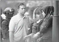  ?? AP/DANIEL CHAN ?? Vietnamese suspect Doan Thi Huong (second from right), is escorted out of court Wednesday in Sepang, Malaysia, where she was charged with murder.