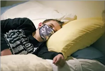  ?? RICK BOWMER — AP ?? Cooper Wuthrich rests as he lays on a bed at the truck stop his family partly owns Tuesday, Dec. 15,
2020, in Montpelier, Idaho. Shortly after Thanksgivi­ng, Wuthrich, 12, became one of hundreds of children in the U.S. diagnosed with a rare
COVID-19 complicati­on that landed him in an emergency room three hours away from his tiny hometown in a secluded Idaho valley. The boy’s parents say he nearly died and their terrifying experience shows why people should wear masks in a conservati­ve state where pushback can be fierce.