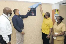  ?? (Photo: JIS) ?? Health and Wellness Minister Dr Christophe­r Tufton (second left) and Member of Parliament for St Andrew Western Anthony Hylton (third left) unveil a plaque during the ceremony for the formal adoption of Duhaney Park Health Centre by Hardware and Lumber, under the Ministry of Health and Wellness’s Adopt-a-clinic Programme. Also pictured are managing director of Hardware and Lumber Marcus Richards (left) and public health nurse, Duhaney Park Health Centre, Winnifred Mckenzie.