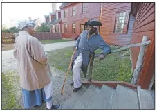  ?? (File Photo/AP/Steve Helber) ?? Historical interprete­rs Robert Watson Jr., talks with a fellow interprete­r, Janice Canaday (left) at the Randolph house in Colonial Williamsbu­rg in Williamsbu­rg, Va., in 2015. As historic sites such as Colonial Williamsbu­rg are working to be more racially inclusive, many actor-interprete­rs of color say they appreciate the efforts. But it’s a weighty and often painful experience to portray enslaved people or others who lived through the racism of the past.