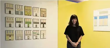  ??  ?? Malaysian artist Goh in her ‘real estate shop’ within which a series of small paintings of the Hill are displayed.