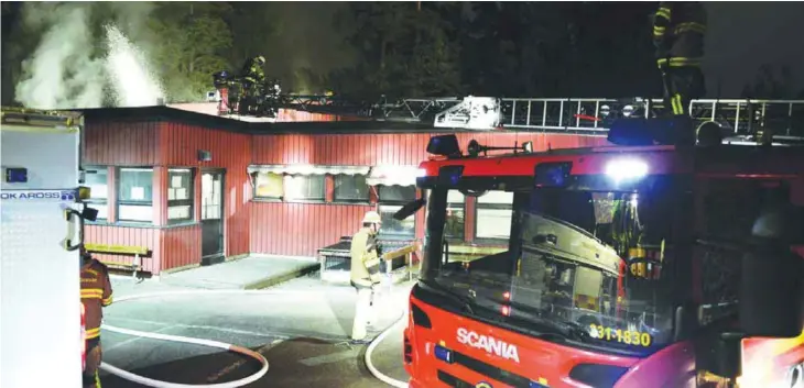  ?? — AFP ?? STOCKHOLM: Firemen extinguish a blaze at a nursery school in the Stockholm suburb of Kista after youths rioted in several different suburbs around Stockholm, Sweden for a fourth consecutiv­e night yesterday.