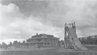  ?? PHOTOS COURTESY THE LOS ALAMOS COMMERCE & DEVELOPMEN­T CORP. ?? Early activities at the Ranch School included building a toboggan slide for the winter months. The Big House, pictured in the background, was torn down by the Atomic Energy Commission in 1947. All that remains of the old school is Fuller Lodge, built in 1928, and the homes of the masters and school staff on Bathtub Row — the only street in the early days of Los Alamos that had homes with bathtubs.