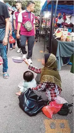  ??  ?? WANITA Kemboja membawa anak ketika mengemis di Bazar Ramadan Taman Politeknik, semalam.