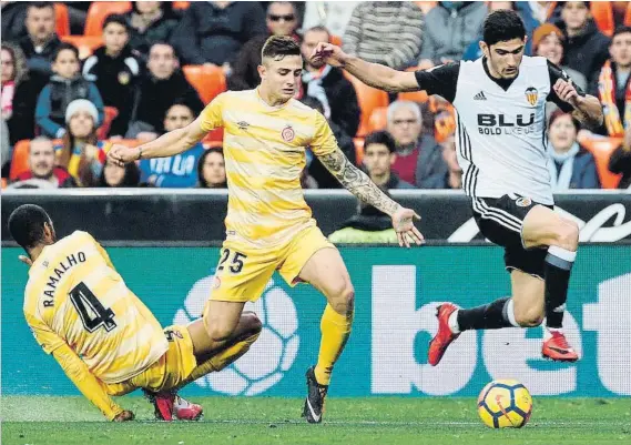  ?? FOTO: EFE ?? Gonçalo Guedes se va de Ramalho y Pablo Maffeo El extremo portugués fue una pesadilla para los defensas del Girona y de sus botas salieron las acciones de los dos goles del Valencia