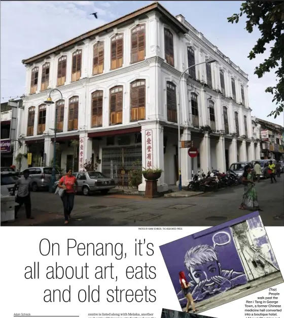  ?? PHOTOS BY ADAM SCHRECK, THE ASSOCIATED PRESS ?? (Top) People walk past the Ren i Tang in George Town, a former Chinese medicine hall converted into a boutique hotel. ( Above) Checking out street art on a wall in George Town.