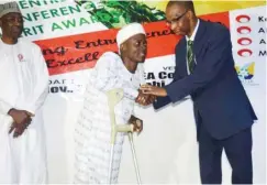  ??  ?? Hassan Abdullahi, a physically challenged person and a beneficiar­y of a grant, is being honoured by the MD of Abuja Enterprise Agency, Mal. Muhammed Tukur Arabi at the FCT Entreprene­urs' Creative Merit Award (FECMA) ceremony in Abuja