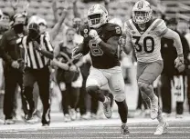  ?? RobertWill­ett / Associated Press ?? North Carolina’s Michael Carter breaks away for a 62-yard TD run. Carter finished with a career-high 214 yards and two TDs.