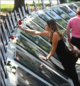  ?? CHRIS RILEY — VACAVILLE REPORTER ?? Justine McKenna places flowers at the memorial for her dad, Vallejo Police Officer Jim Capoot, during Solano County's 34th Peace Officers Memorial Service on Wednesday in Fairfield.