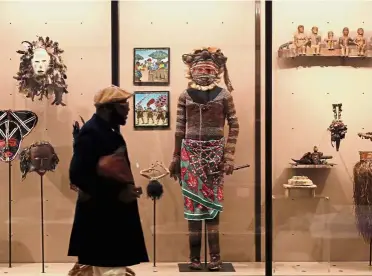  ?? — Reuters ?? Closer look: A journalist viewing African artefacts at the museum.