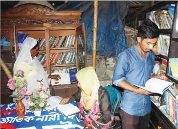  ?? THE DAILY STAR ?? Young men and women look at books in Shapla Pathagar, a library that Safia Begum started in her own home in Bangladesh.