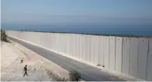  ?? An Israeli soldier stands near a wall at the Israel-Lebanon border near Rosh Haniqra, northern Israel. ??