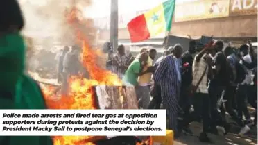  ?? ?? Police made arrests and fired tear gas at opposition supporters during protests against the decision by President Macky Sall to postpone Senegal's elections.