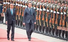  ?? FRED DUFOUR, AFP/GETTY IMAGES ?? Luxembourg’s Prime Minister Xavier Bettel, right, and Chinese Premier Li Keqiang inspect members of an honor guard during a welcoming ceremony Monday at the Great Hall of the People in Beijing. Bettel is on a four-day visit to China.