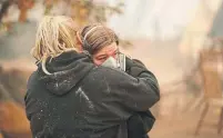  ?? JOHN LOCHER THE ASSOCIATED PRESS ?? Krystin Harvey comforts her daughter Araya Cipollini on Saturday at the remains of their home burned in the Camp Fire.