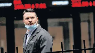  ?? REUTERS • MIKE SEGAR ?? A trader walks past a digital stock price display outside the New York Stock Exchange in Manhattan.