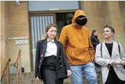  ?? /Reuters ?? Reckoning: A Ukrainian man who alleges he was tortured by Russian forces walks with Tsvetelina van Benthem, a University of Oxford legal scholar, and Ukrainian journalist Nataliya Gumenyuk outside a court in Buenos Aires, Argentina, on Monday.