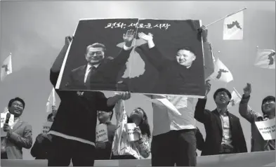  ??  ?? ESPERANZA. Activistas por la paz sostienen las imágenes del presidente surcoreano Moon y de Kim Jong Un.