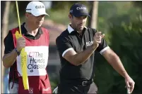  ??  ?? Charl Schwartzel, right, talks to his caddie on the eighth hole during the first round of the Honda Classic on Thursday.