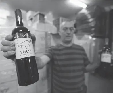  ?? MENAHEM KAHANA / AFP / GETTY IMAGES FILES ?? Amichai Luria with bottles of his wine at the Shilo winery in the occupied West Bank. The CFIA has reversed a decision that initially told wine sellers it was unacceptab­le to label Israel as the country of origin for West Bank wines.