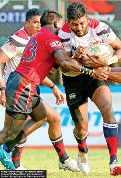  ??  ?? Kandy's Danush Dayan attempts to breach through CR's Kevin Dixon and Mohamed Sashan - Pic by Priyantha Wickramaar­achchi