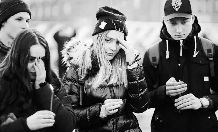  ?? ALEXANDER ZEMLIANICH­ENKO
THE ASSOCIATED PRESS ?? People in Moscow hold the candles to commemorat­e the victims of Sunday’s fire in a shopping mall in the Siberian city of Kemerovo.