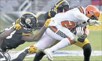  ?? Matt Freed/Post-Gazette photos ?? Steelers linebacker­s Vince Williams, left, and T.J. Watt take down the Browns’ Duke Johnson in the second quarter Sunday at Heinz Field.