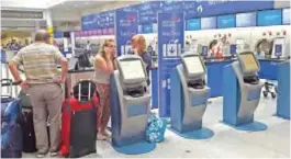  ??  ?? LONDON: Passengers stand at a British Airways check-in desk after the airport suffered an IT systems failure, at London”s Gatwick Airport. Shares in British Airways’ parent company tumbled yesterday after a catastroph­ic IT failure stranded thousands of...