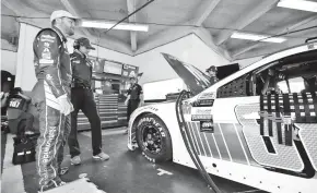  ?? GETTY IMAGES ?? Dale Earnhardt Jr. examines his car in the garage at Daytona Internatio­nal Speedway.